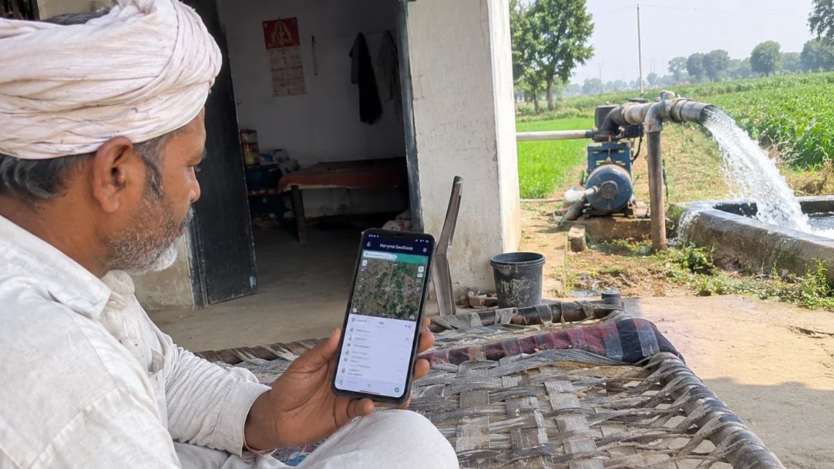 हरियाणा के किसान मोबाइल पर जियोस्टैक ऐप से जमीन का नक्शा और रिकॉर्ड देखते हुए एआई से बनी साकेंतिक फोटो